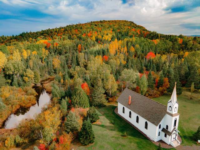 a church sits among fall color