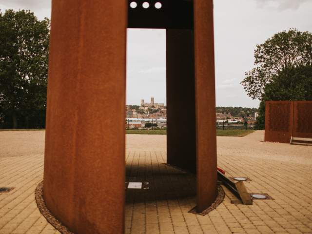 A memorial with Lincoln Cathedral in the background at International Bomber Command Centre