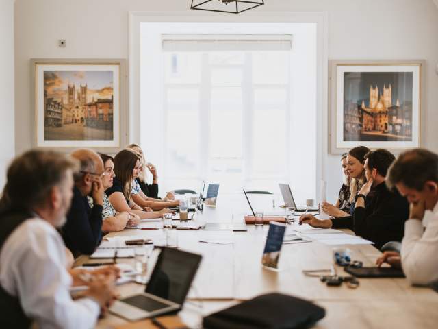 A board meeting of Destination Lincolnshire with people sat around a table with laptops