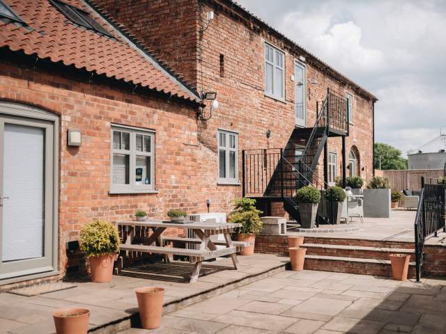 Accommodation exterior with picnic benches and plants