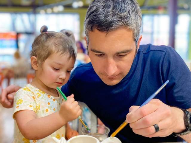 father and daughter painting a mug