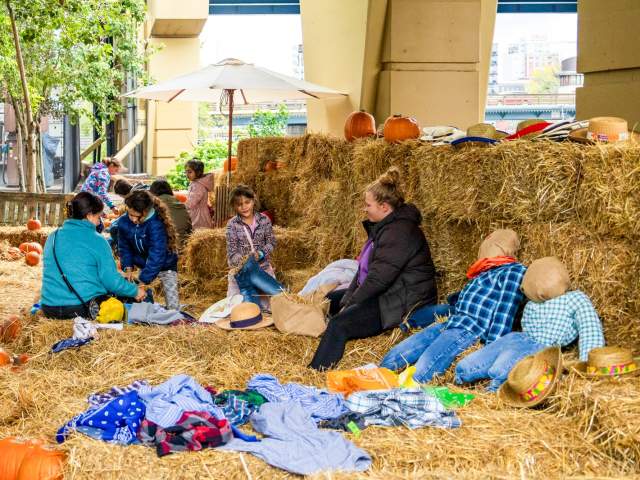 People sitting on bales of hay at the Milwaukee Public Market Harvest Festival
