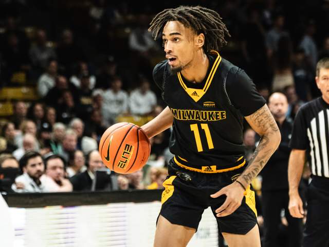 a basketball player in UW-Milwaukee Panther uniform mid-game