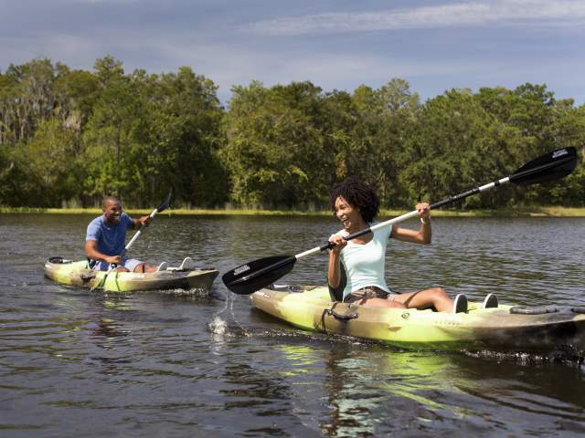 Couple paddling kayaks on a lake at JW Marriott Orlando, Grande Lakes