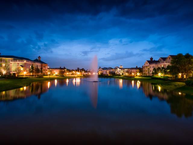 Disney's Saraoga Springs Resort & Spa exterior with lake in foreground at evening
