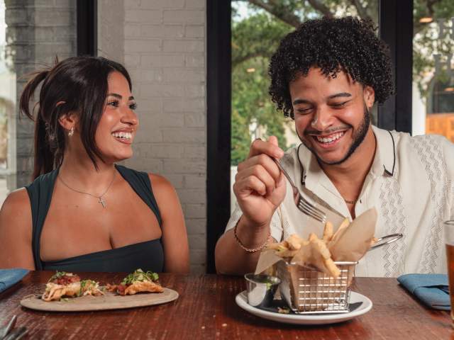 A couple smiles and laughs over appetizers at Boca Winter Park