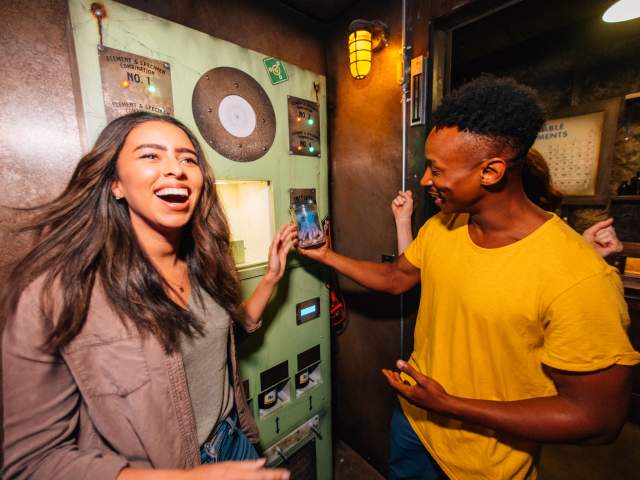 A young adult couple discover a mysterious octopus in a jar while in The Depths escape room at The Escape Game Orlando.