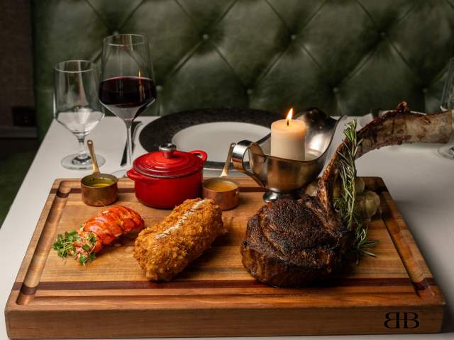 Lobster tail, steak, wine and more decadent options on a table at Bull & Bear