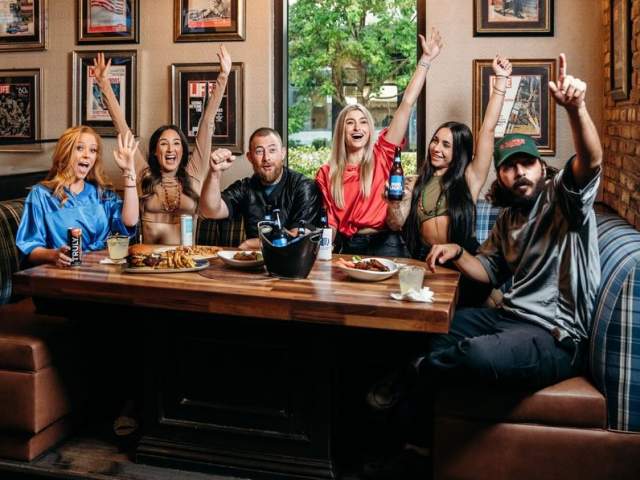 Friends cheering at American Social Bar & Kitchen