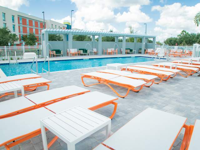 Pool, pool chairs and wheelchair lift at Holiday Inn & Suites Orlando I-Drive South