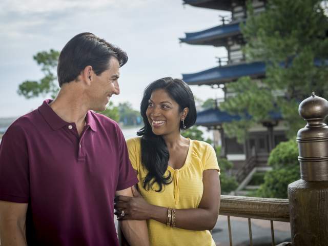 A couple smile at each other as they walk through the Japan pavilion at EPCOT, part of Walt Disney World Resort