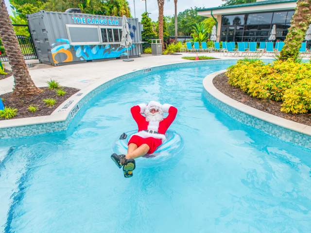 Santa unwinds on a inner tube, hands behind his head, as he floats along the lazy river at Orlando World Center Marriott
