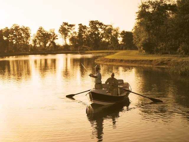 Two men fishing on a boat at The Ritz-Carlton Orlando, Grande Lakes