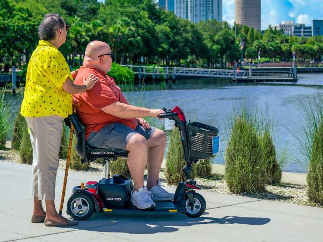 A man in a Cloud of Goods ECV rental and a woman in a cane gaze out at the lake