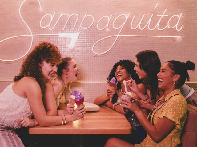 A group of ladies sitting at a booth, laughing and eating ice cream at Sampaguita Ice Cream