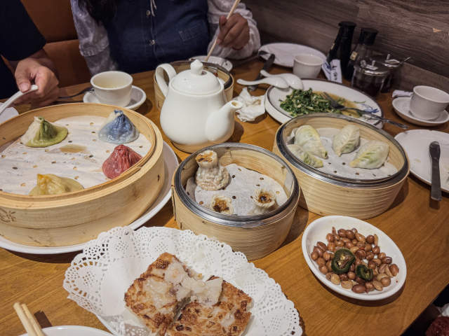 Tabletop spread of several dumpling dishes at One Stop Dumpling