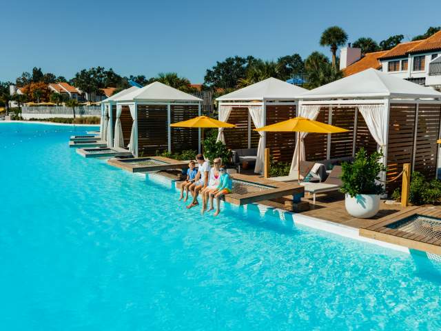 Family sitting in a pool hammock at a Bayside Cabana