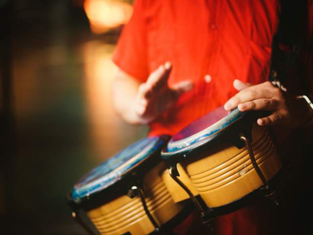 Detail of a man hands playing vintage bongos - right hand little blurry due to movement