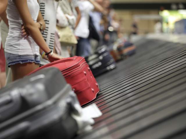 Suitcase on luggage conveyor belt in the baggage claim at airport