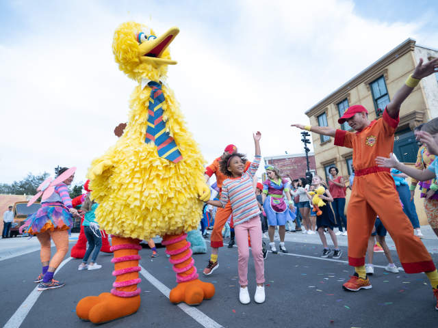 Little Girl dancing with Big Bird in Sesame Street Parade at Seaworld