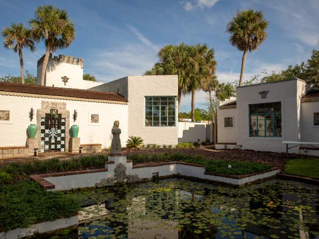 Courtyard, pond and white stone buildings of the Maitland Art Center