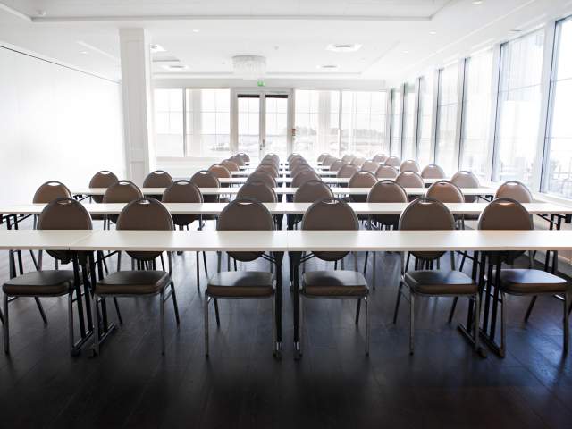 En rekke bord og stoler i konferanserom 2
