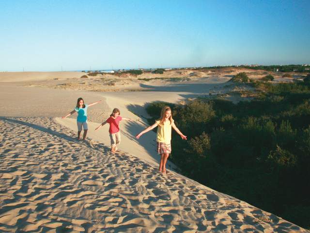Children walking on sand dunes on the Outer Banks