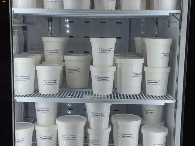 A refrigerator with pints of ice cream in it