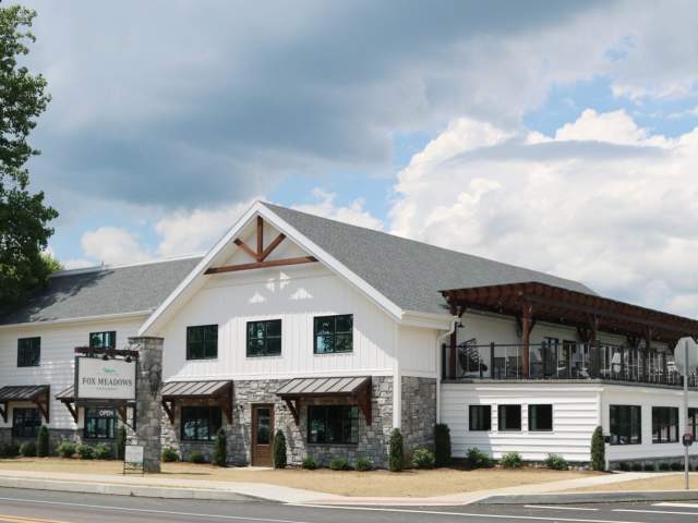 Exterior of a large white, ice cream shop with a balcony patio on the second floor