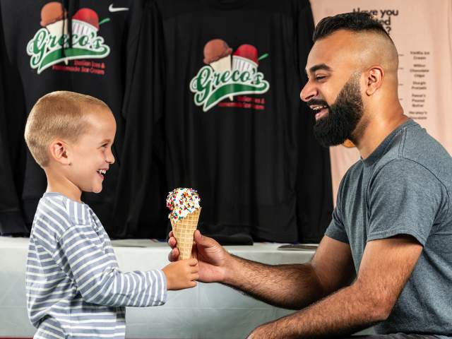 Old man giving a young boy a cone of ice cream