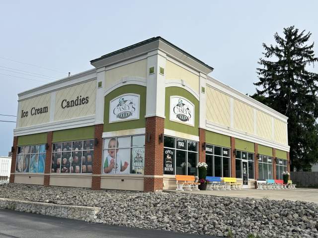 Exterior of a stand alone store with text on the side that reads Ice Cream, Candies