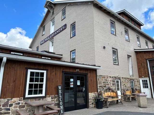 Exterior of a three-story ice cream shop with a Welcome sign out front