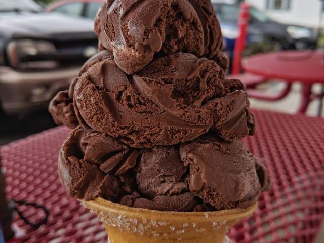An ice cream cone with two scoops of chocolate ice cream