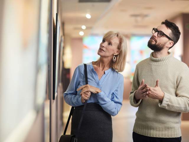 At man and woman admiring artwork on a wall