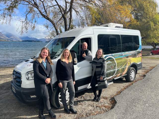 Appellation team stand with a new Ford E-transit passenger van