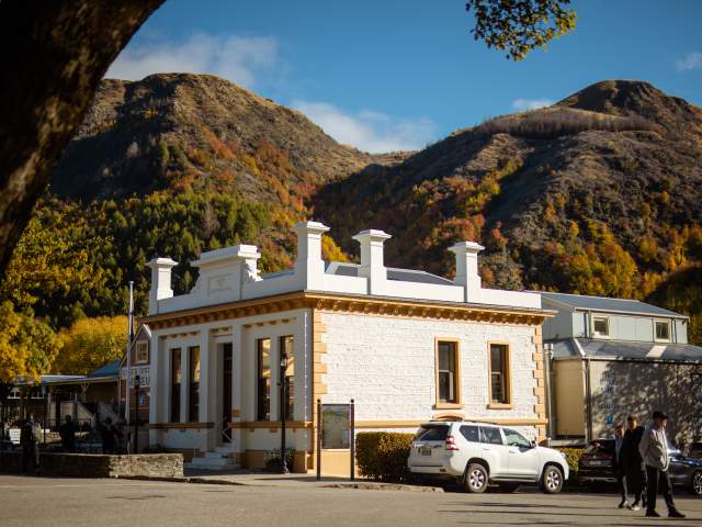 A historic building on a street corner with mountains
