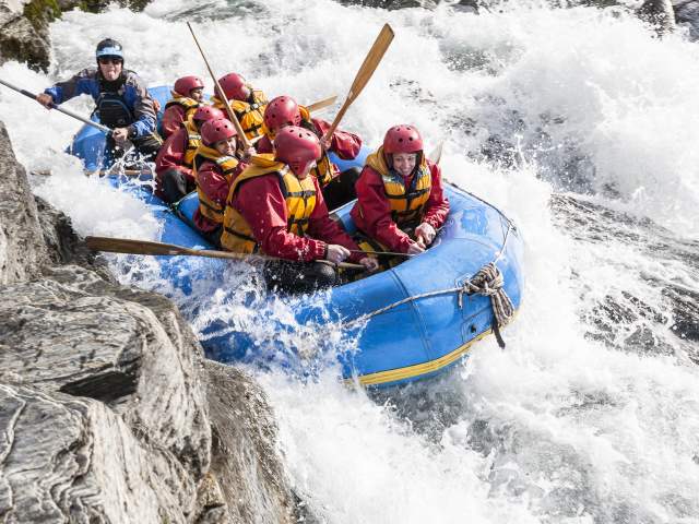 Rafting boat through white water rapids