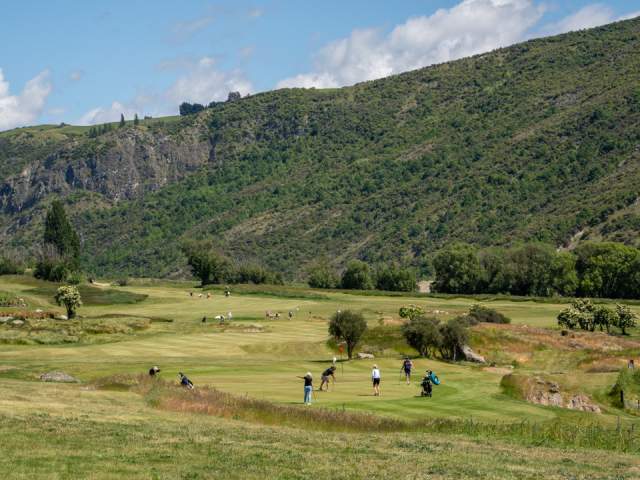 A landscape photo of golfers playing at the new Gibbston Valley Golf Course