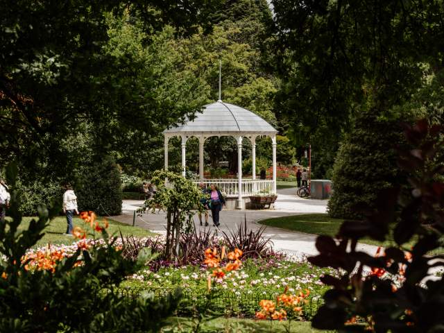 A couple walking the beautiful Queenstown Gardens loop with the verandah in the background