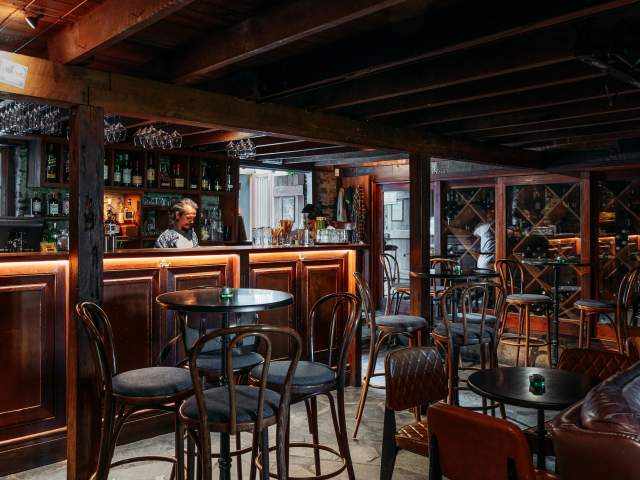 The inside of an old pub with wooden and leather furnishings