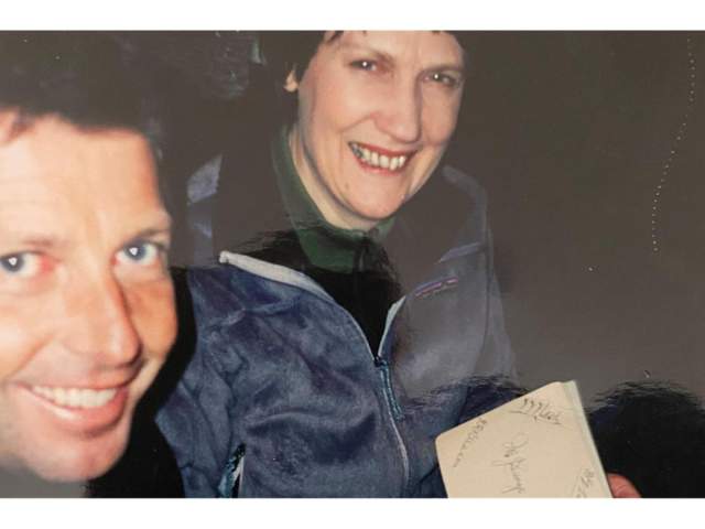 DK asking PM Helen Clark to sign his family heirloom autograph book.
