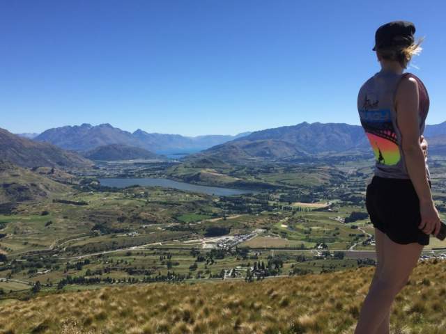 Woman looking over view of town and mountains from the top of Mt Beetham