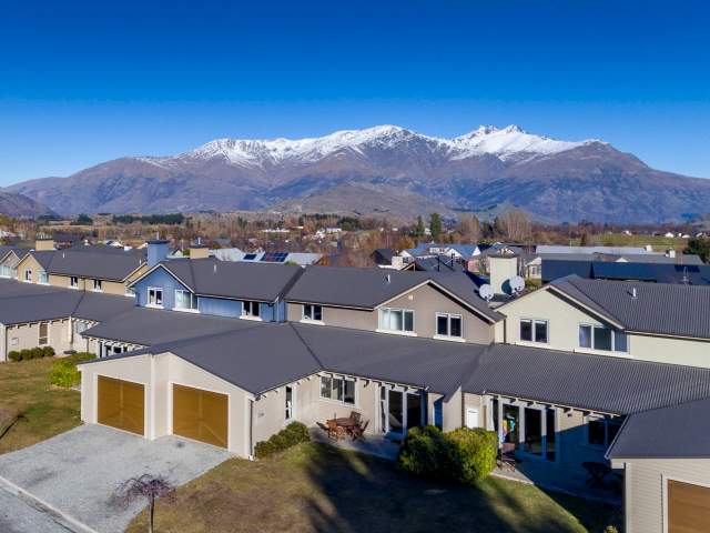 Aerial view of Arrowfield Apartments with snow-capped mountains in the background