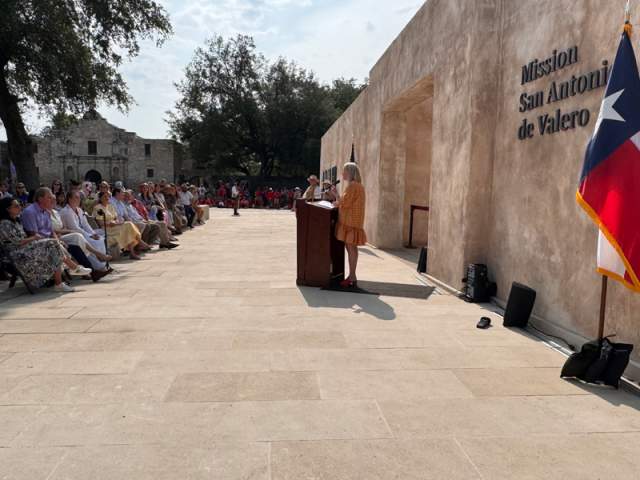 Woman speaking to crowd in front of new entrance at the Alamo