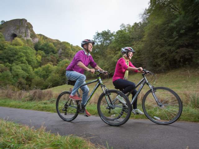 couple on a bike ride with Thor's Cave in background