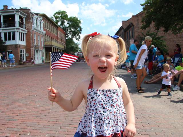 Kid at Riverfest Parade, waving flag