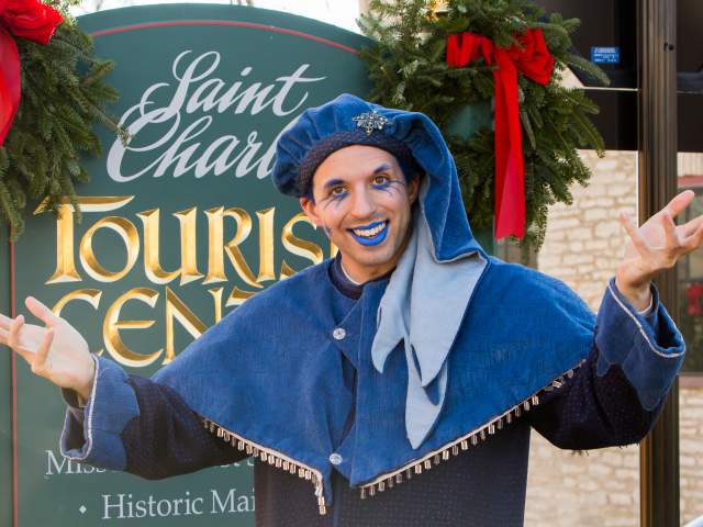 One of the characters from Christmas Traditions, Jack Frost, stands in front of the Tourism Center sign in St. Charles, MO.