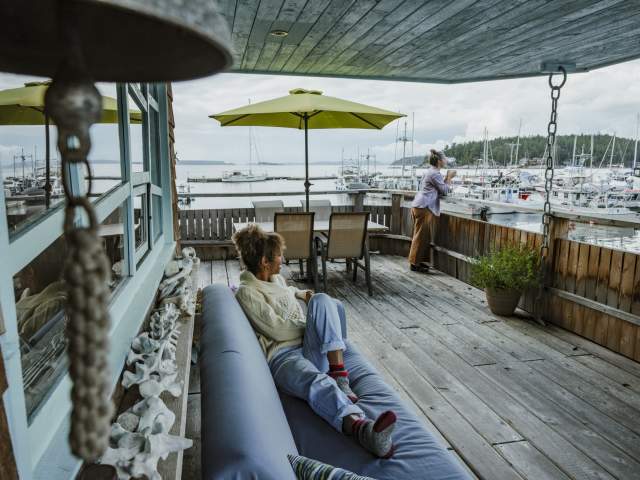 Two women enjoying the marina views from a covered patio.