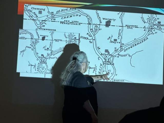 DeeAnne Wymer points to a map of an archaeological site organized by Louise Welles Murray.
