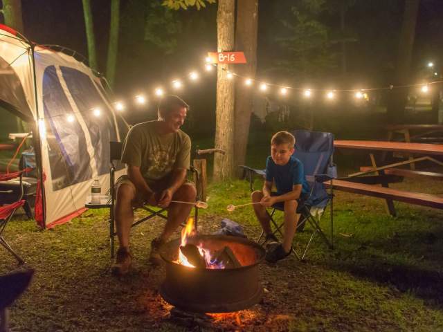 Father and Son sitting by the fire at Knoebels Campground